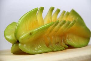 slices of starfruit well arranged on wooden cutting board photo