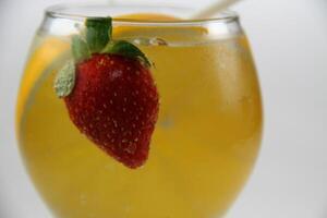 un vaso de agua con fresas y un naranja rebanada foto