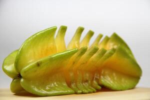 slices of starfruit well arranged on wooden cutting board photo