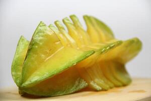 slices of starfruit well arranged on wooden cutting board photo