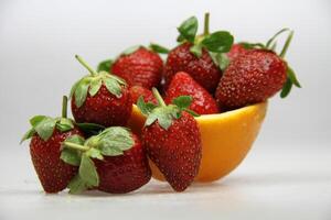 a bowl of strawberries and an orange photo