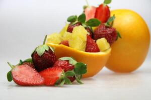 a fruit bowl with strawberries, oranges, and slice of star fruit photo