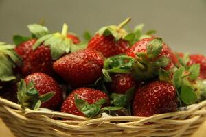 a basket of strawberries on a wooden cut board on white background photo