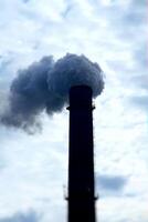 Smoke stack of industrial factory contamibates air with toxic smoke photo