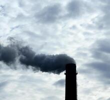 chimenea de industrial fábrica contaminador aire debajo niebla tóxica en el cielo foto