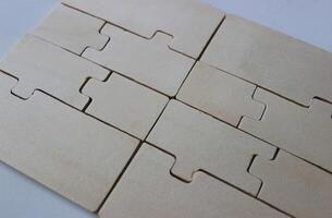 Rectangular panel of tightly folded plywood puzzles on a white surface photo