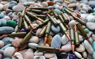 Small coastal stones with randomly scattered live ammunition photo