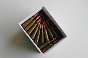 Top view of white box with unitary cartridges lined up bullets to bullets in a white box photo