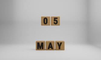 wooden cubes with arranged letters. May and 05 on blurry white background photo