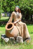 Armenian young woman in traditional clothes in the nature in summer photo