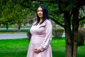 el embarazada mujer en el parque, hermosa mujer en el parque, embarazada mujer en primavera foto