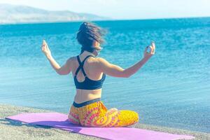 perrson doing yoga exercise on the beach, person relaxing on the beach, personn doing yoga photo