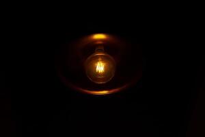 light bulb in the dark, light bulb on black background photo