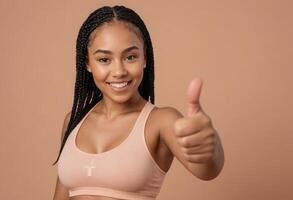 AI Generated A young athletic woman with braided hair gives a thumbs up. photo