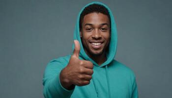 AI Generated A friendly young man in a teal hoodie smiles and gives a thumbs up, exuding a casual, approachable vibe. photo