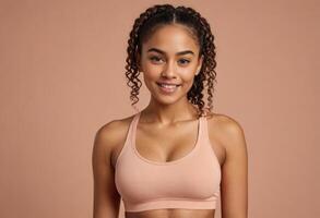 AI Generated A radiant woman with curly hair smiles in a pink sports bra, conveying a sense of health and vitality against a peach backdrop. photo