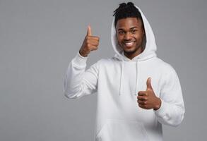 AI Generated A cheerful black man in a white hoodie gives a thumbs up, smiling warmly at the camera. photo