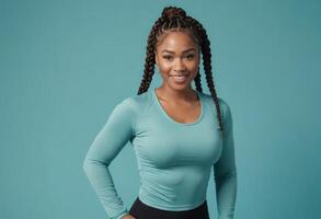AI Generated A woman with braided hair stands confidently, hands on hips in a teal fitness top. Her posture suggests strength and determination. photo