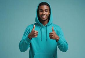 AI Generated A man in a teal hoodie gives a double thumbs-up, his smile welcoming and friendly against a matching teal background. photo