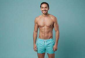 AI Generated A man with a toned build and a beaming smile stands in light blue swim shorts against a teal background. photo