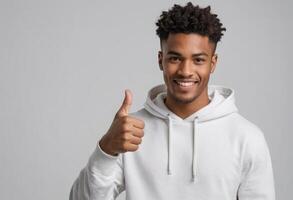 AI Generated A friendly young man in a white hoodie giving a thumbs up, grey background. His relaxed posture and smile indicate ease and friendliness. photo