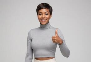 AI Generated A confident woman in a grey crop top giving a thumbs up. Her stylish look and positive gesture signal approval. photo