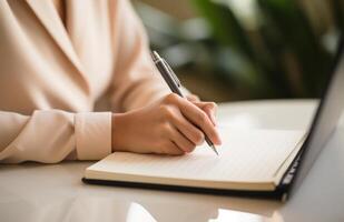 AI generated a businesswoman writes in an old notebook while sitting next to a laptop keyboard photo