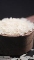 Raw white rice on a wooden spoon video