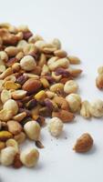 close up of many mixed nuts on white background video