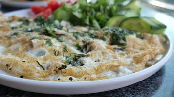 Plain Egg Omelette mixed with herbs on table video