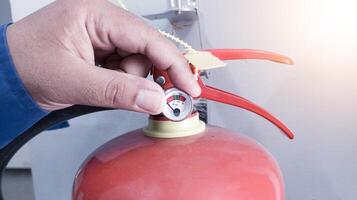 cheque y inspección el presión calibre válvula fuego extintor, condición polvo en el tubo fuego extintor. foto