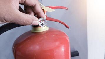 cheque y inspección el presión calibre válvula fuego extintor, condición polvo en el tubo fuego extintor. foto