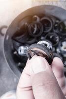 Hand holding the valve spring and  seal  is broken ,part  of the water jet pump. photo