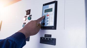 The Technician setting the parameter of the Over Current Rellay on control cubicle panel. photo