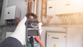 Checking and measuring solar panels using a multimeter, repairing power cable lines in solar panel inverters. photo