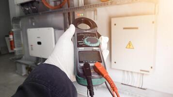 Checking and measuring solar panels using a multimeter, repairing power cable lines in solar panel inverters. photo