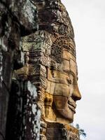 antiguo Roca tallado cara a bayon templo en siem recoger, Camboya foto
