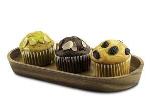 Different kind of muffins in wooden tray isolated on white background with clipping path photo