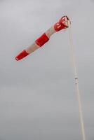 Red and white windsock with gray sky photo