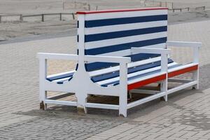 old blue and white wooden bench on the beach promenade photo