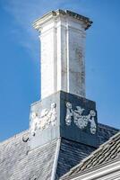 Old brick and decorated chimneys on the roof photo