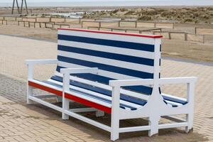 old blue and white wooden bench on the beach promenade photo