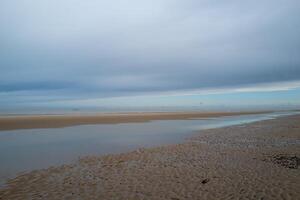 the coast at low tide with beach in the early morning of De Haan, Belgium photo