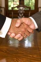 AI generated Diverse business partners handshake over wooden table photo