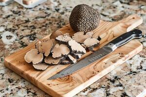 AI generated Black truffles on the cutting board. photo