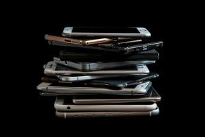 AI generated A pile of different smartphones isolated on a black background. photo