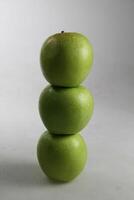 a stack of three green apples on white background photo