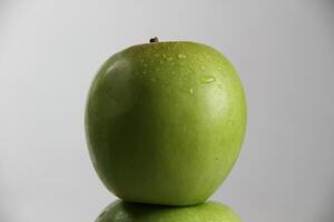 un apilar de Tres verde manzanas en blanco antecedentes foto