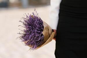 Purple bouquet in the hands of a woman close-up photo