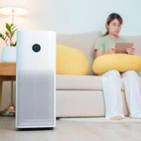 Air Purifier with woman relax and use tablet on sofa. Purification system for filter and cleaning dust PM2.5 HEPA and virus in home. Allergy, Pure air, health, Wellness lifestyle and Air Pollution photo